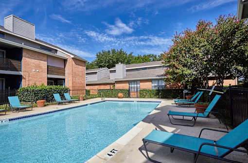 A pool surrounded by chairs and trees at 1601 Eastchase Pkwy in Fort Worth, TX.