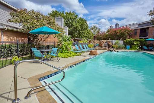 A pool with a metal ladder and a blue umbrella at 1601 Eastchase Pkwy in Fort Worth, TX.