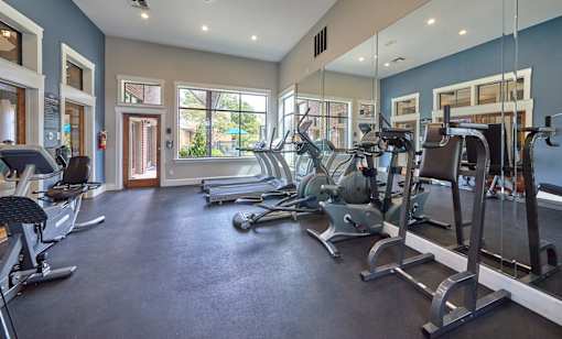 A spacious gym with treadmills, elliptical machines, and other exercise equipment at 1601 Eastchase Pkwy in Fort Worth, TX.