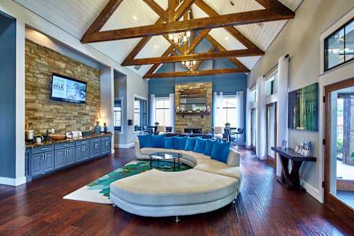 A large, open resident clubhouse room with a stone wall and a wooden ceiling at 1601 Eastchase Pkwy in Fort Worth, TX.