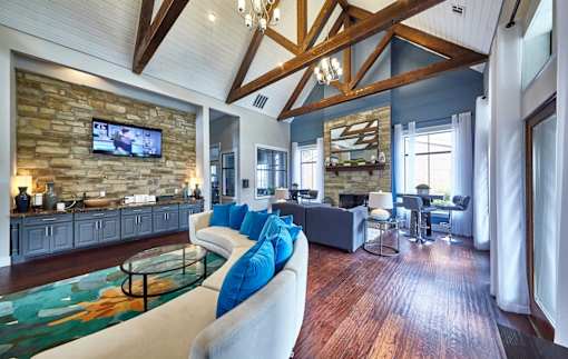 A resident clubhouse room with a stone wall and a glass coffee table at 1601 Eastchase Pkwy in Fort Worth, TX.