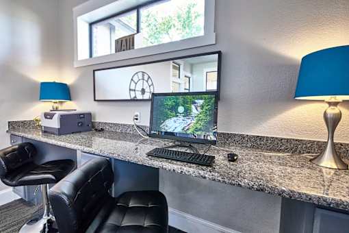 A black chair is in front of a desk with a computer and a monitor at 1601 Eastchase Pkwy in Fort Worth, TX.
