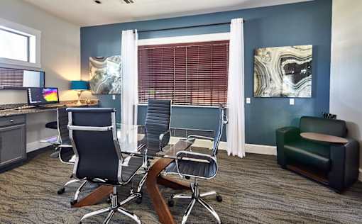 A conference room with a desk, chairs, and a computer setup at 1601 Eastchase Pkwy in Fort Worth, TX.