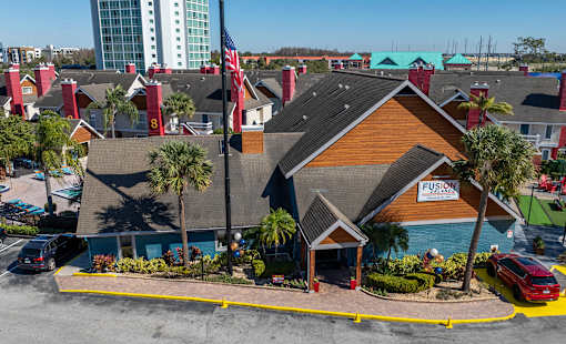 A building with the word Fusion on it is surrounded by palm trees.