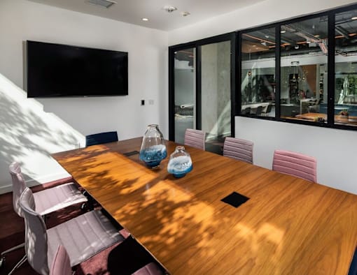 Fusion Encore Hollywood Apartments conference room with a wooden table and chairs.