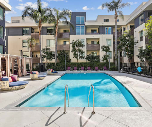 Fusion Encore Hollywood Apartments swimming pool in front of a modern apartment building.