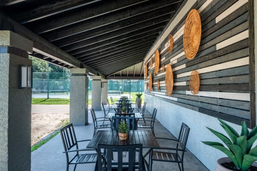 outdoor seating area at Fusion Fort Worth Apartment complex in Haltom City, Texas with modern greyscale siding and black metal patio furniture