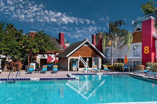 Fusion Orlando apartments pool with a wooden building in front of it.