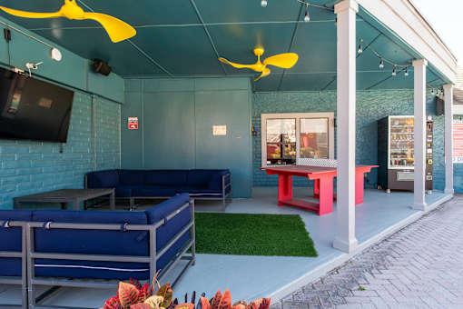 A blue couch and a red table are in front of a blue wall at the Fusion Orlando apartments.