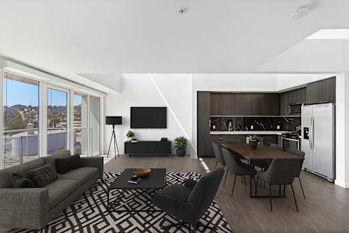 Fusion Hollywood apartments modern living room with a grey sofa, black and white rug, and a wooden dining table.