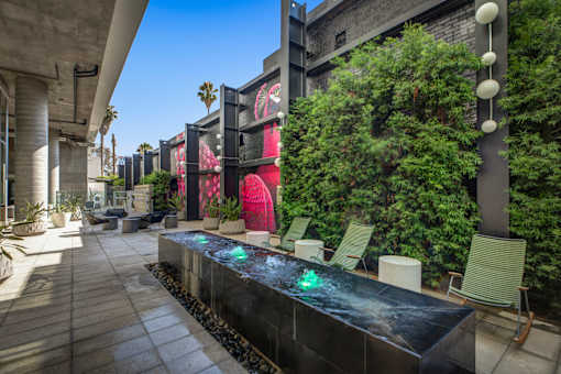 Apartments at 5750 Hollywood Blvd, Los Angeles, CA 90028 long black bench with a water feature in the middle.
