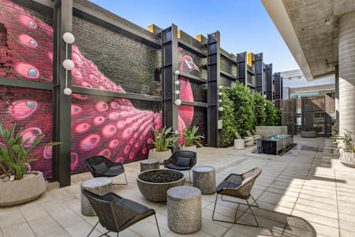 Fusion Hollywood Apartments (previously Alta Ink Apartments) courtyard with a mural of peacock feathers on the side.