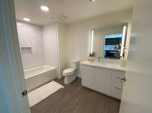 Apartments on Hollywood Blvd Los Angeles with white bathroom with a toilet, sink, and bathtub.