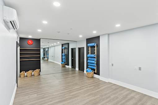 Fusion Encore Hollywood Apartments yoga studio with a white wall and a red sign on it.