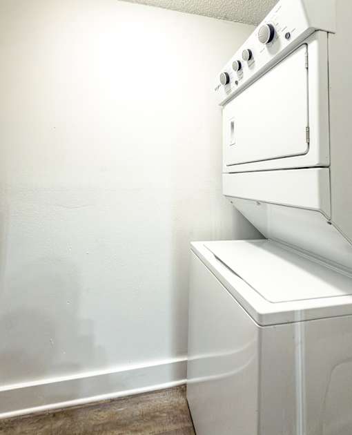 An in-unit white washer and dryer in a small room at Mandarin Bay Apartments.