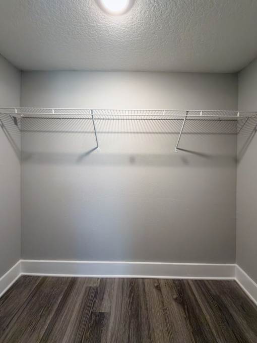 A white closet with a shelf and a light on at Mandarin Bay Apartments