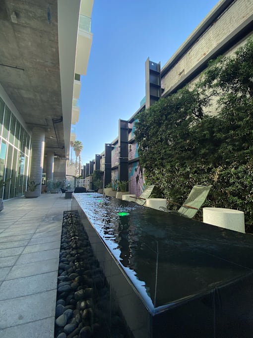 Apartments at 5750 Hollywood Blvd, Los Angeles, CA 90028 long black bench with a water feature in the middle.