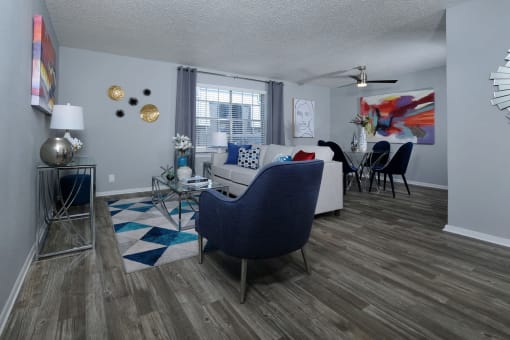 Arlington, TX apartments living room and dining area in Stadium 700 apartments with modern furniture, luxury plank flooring, and large window.