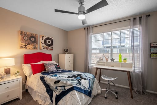 Bedroom in Stadium 700 Apartments near UTA - 2 bedroom apartments in Arlington, TX with large window, ceiling fan, and luxury carpet
