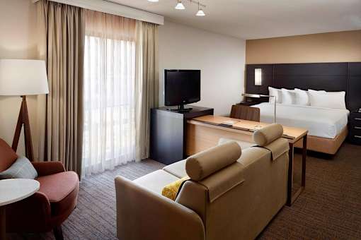 A furnished apartment at Fusion Buckhead with a bed, couch, and television.