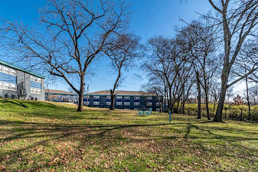 Exterior of The Canvas Apartments in Nashville with a blue facade is surrounded by bare trees.