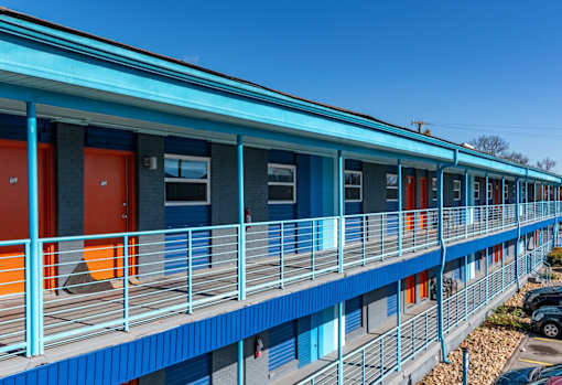 A blue and orange building with a metal railing at The Canvas Nashville Apartments.
