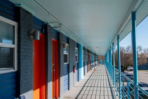 The Canvas Apartments in Nashville outdoor corridor with blue walls and orange doors.