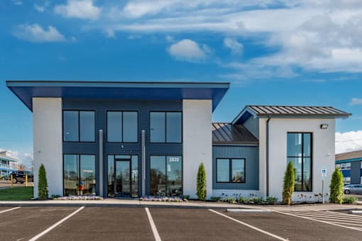 The Canvas Apartments Nashville modern leasing office building with a blue roof and glass doors.