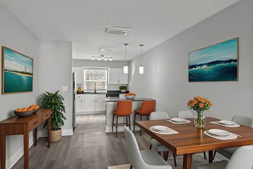 A dining room with a wooden table set for four at Mandarin Bay Apartments.