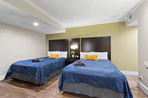 Two beds with blue bedspreads in a bedroom at Fusion Orlando.
