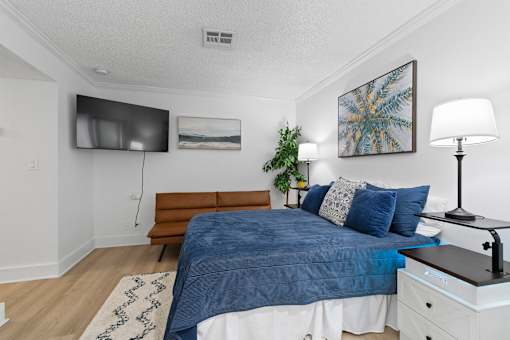 A bedroom with a blue comforter on the bed.