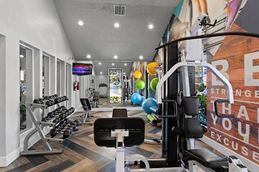 Fusion Orlando fitness center with a variety of equipment including a weight bench, dumbbells, and a treadmill.