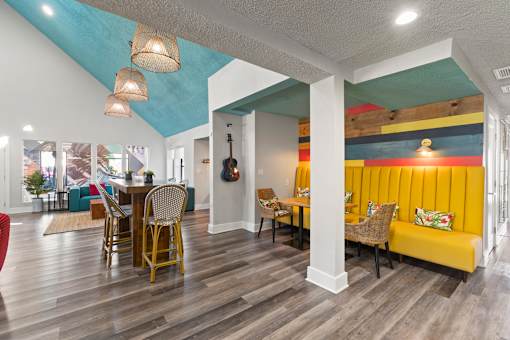 A room with a wooden floor and a yellow couch at the Fusion Orlando clubhouse