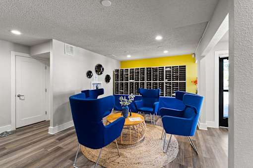 A living room with blue chairs and a wicker table.