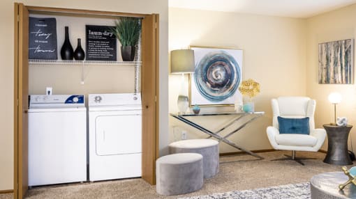 a laundry room with a washer and dryer and a living room with furniture