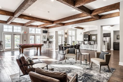 The Fort gathering area with four couches, next to a table surrounded by chairs, and a pool table.