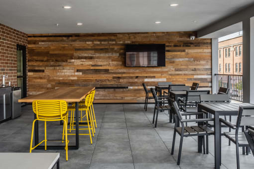 a restaurant with a wooden wall and yellow chairs