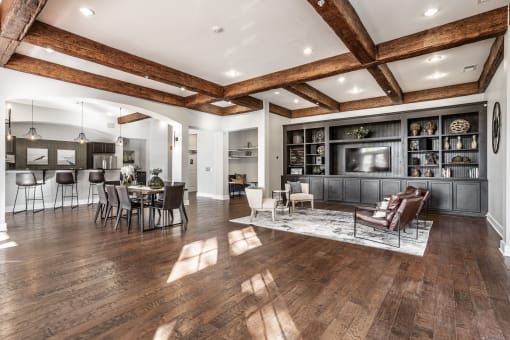 A community lounge in Indianapolis, IN with a selection of seating areas on hardwood-style flooring.