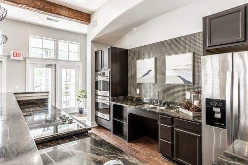 A communal kitchen at The Fort with stainless steel appliances, modern decor, and a large window.