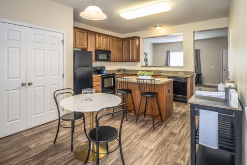 Arbors at Turnberry Apartments Pickerington Ohio Pet Friendly Updated Modern Kitchen wood style flooring, stone style countertops, kitchen island, dining area, and pantry