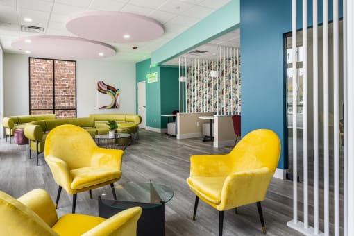 a lounge area with yellow chairs and green couches