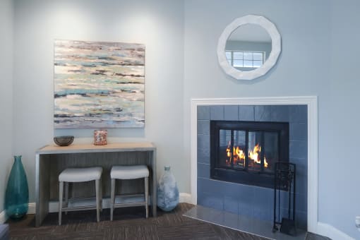 Living area with a fireplace, casual seating, and a bistro-style table with two stools