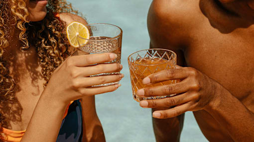 A man and a woman holding glasses of a beverage.