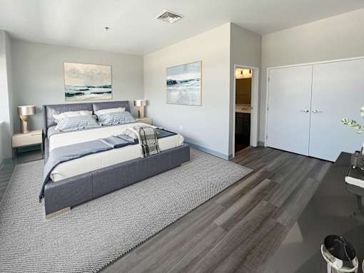 A bedroom with a large bed and a painting on the wall.