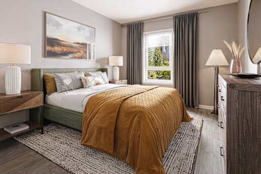 A bedroom with a large bed and a painting on the wall.
