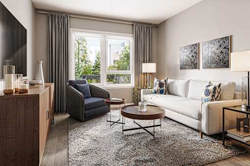 A living room with a blue couch, a white couch, and a coffee table.