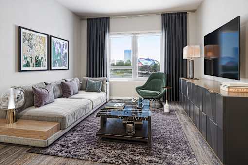 A modern living room with a grey sofa, a green armchair, a coffee table, and a flat-screen TV mounted on the wall.