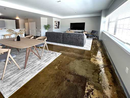 A living room with a grey couch and a wooden table.