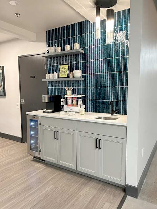 A kitchen with a sink, a refrigerator, and a cabinet.