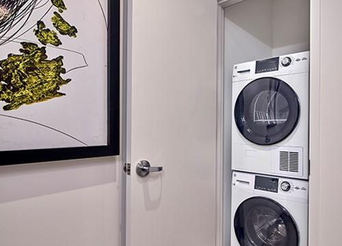 a white door with a washer and a dryer in a room